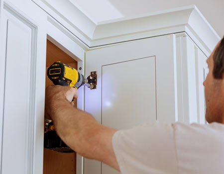 man installing kitchen cabinets